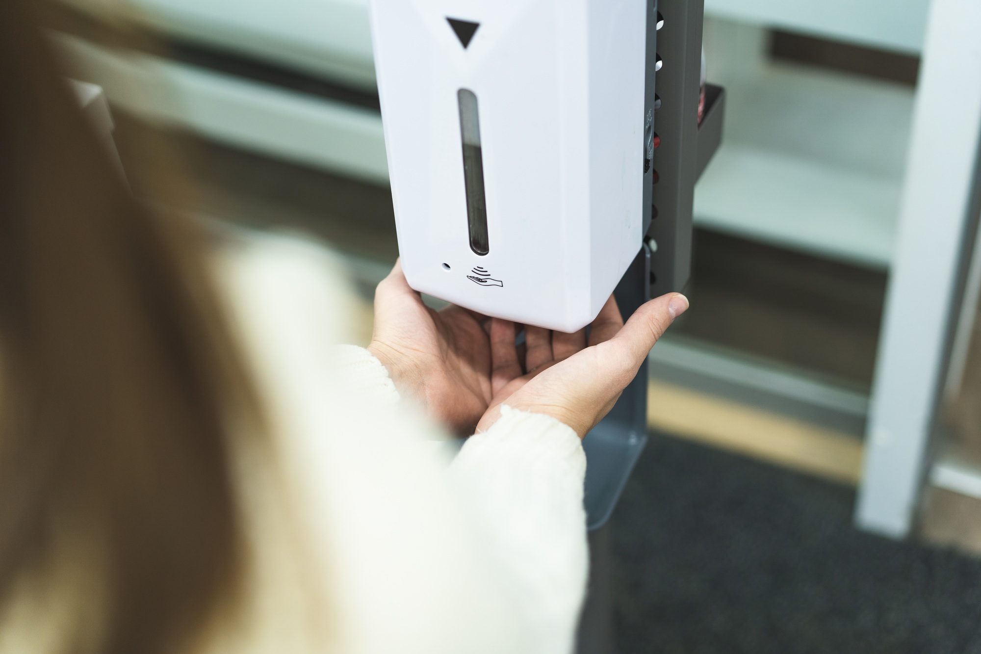 Cleaning, washing hands using automatic sanitizer dispenser concept.